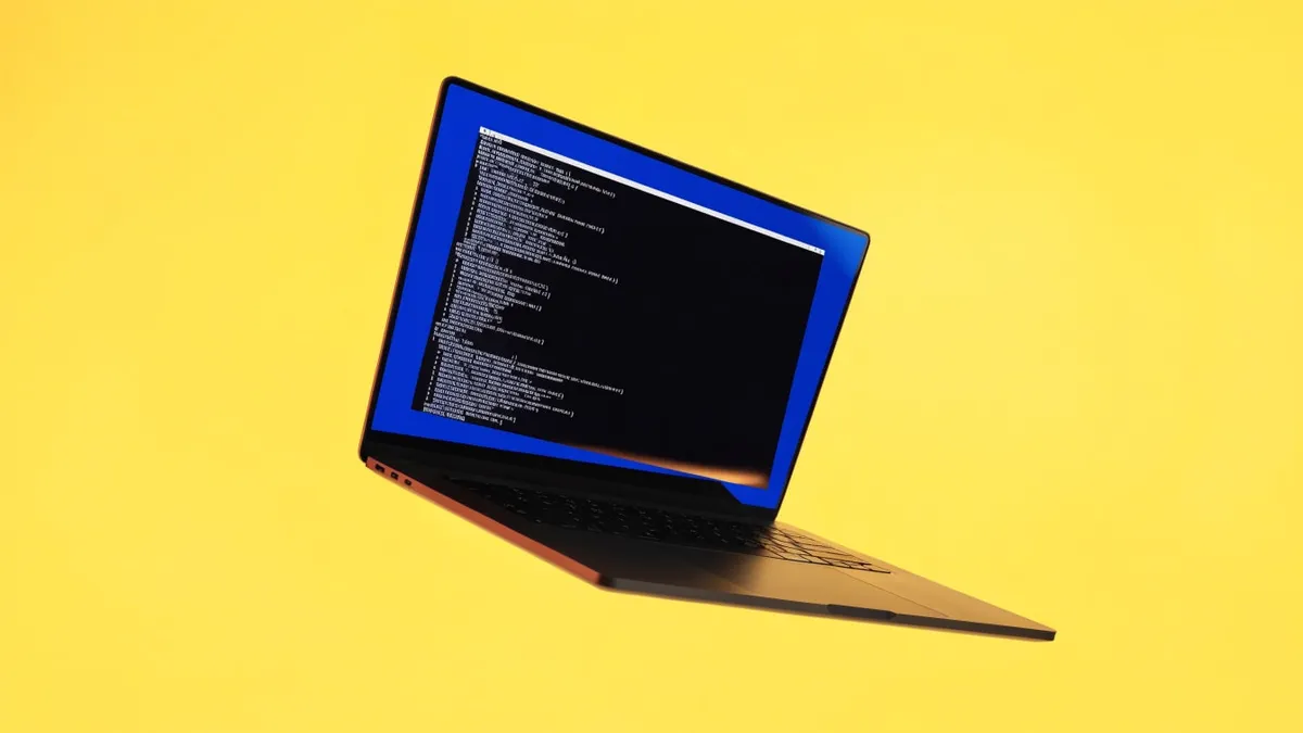 A laptop with lines of code on its screen, cut out against a solid bright color.