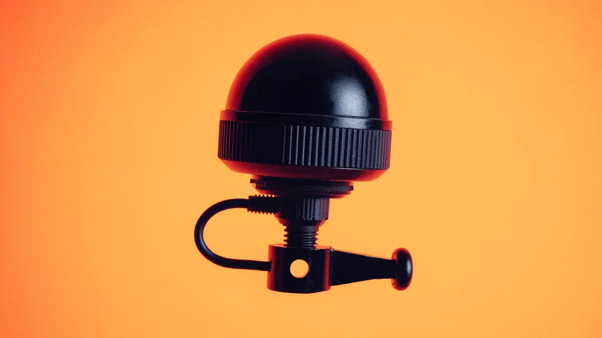 A gray surveillance camera on a short bracket, cut out against a solid bright color.