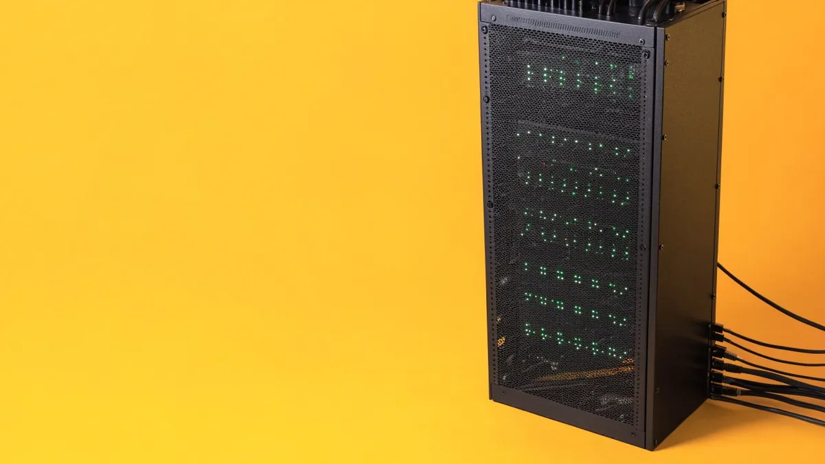 A black server rack with rows of green status lights, cut out against a solid bright yellow background.